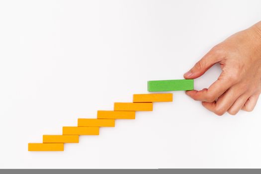 Business concept for growth success process, hand stacking wood block as step stair