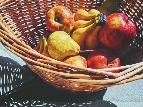 Organic apples, pears and bananas on rustic in a wicker basket, fruits farming and agriculture