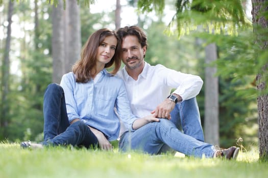 Married couple of people sitting on grass
