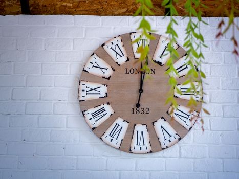 retro wall clock distressed and weather worn with Roman numerals on a wall