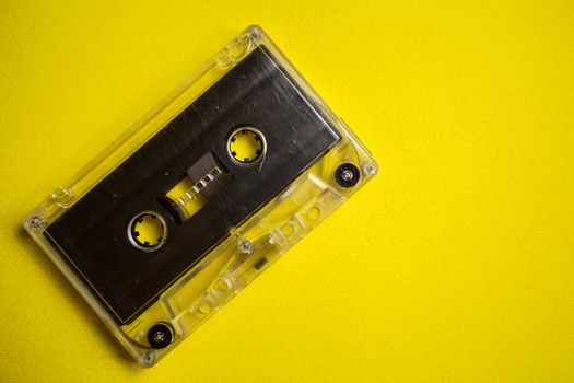 Retro audio cassette on a yellow background, music