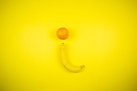 Fruit banana and orange on a yellow background, fruits