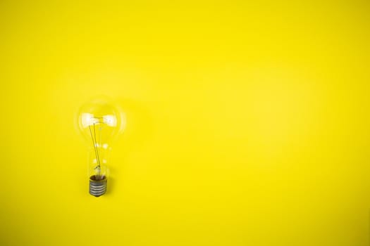 An idea came up. Light bulb on a yellow background, tehnology