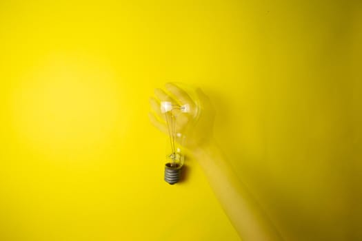 An idea came up. Light bulb on a yellow background, tehnology