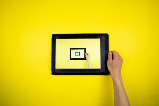 Tablet in hands on a yellow background. Picture in Picture