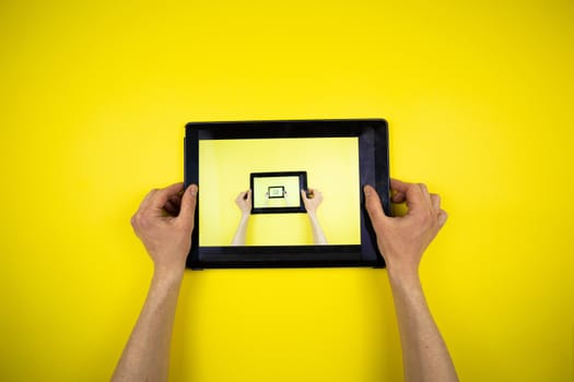 Tablet in hands on a yellow background. Picture in Picture