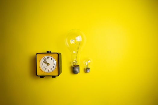 Yellow alarm clock and light bulb