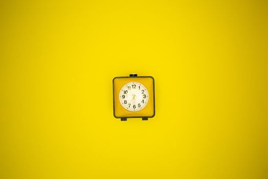 Yellow alarm clock on a yellow background