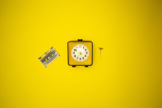 Yellow watch. Alarm clock and wild flower