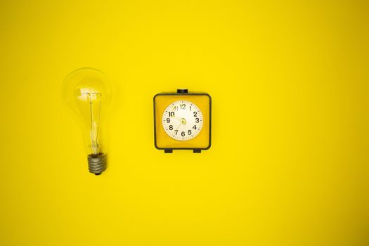 Yellow alarm clock and light bulb