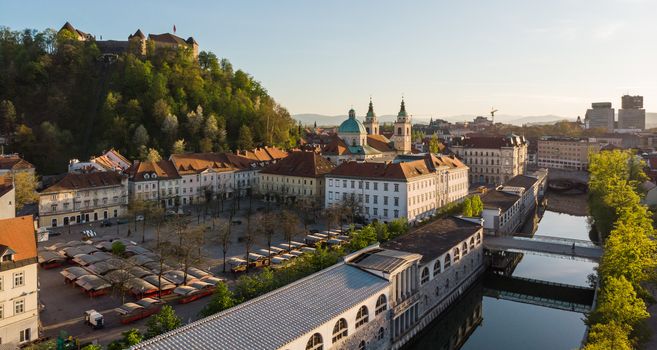 Aerial drone panoramic view of Ljubljana medieval city center, capital of Slovenia in warm afternoon sun. Empty streets during corona virus pandemic social distancing measures.