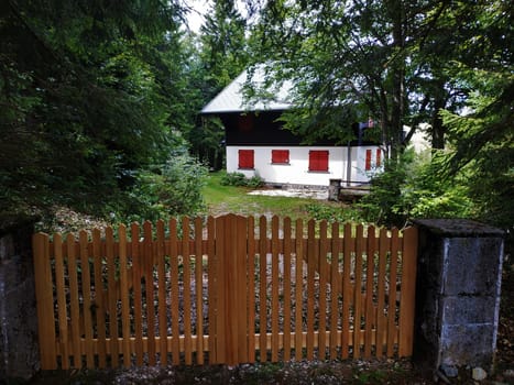 Beautiful hut with red window blinds behind fence near Le Markstein, France