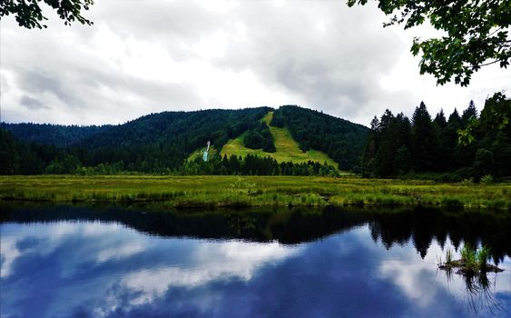 Blue sky reflecting in Lispach lake near La Bresse, France