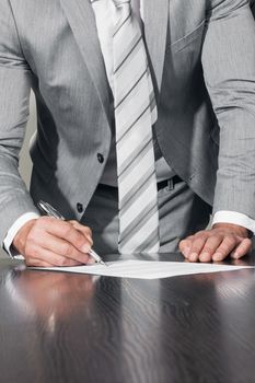 Work process and deal concept. Businessman with pen in hand reading official business contract before making a deal and signing document, close up view