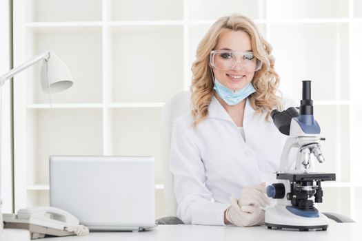 Portrait of a female researcher or medical doctor doing research using microscope in a laboratory