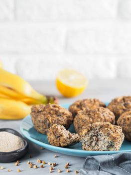 Close-up view of healthy gluten-free homemmade banana muffins with buckwheat flour. Vegan muffins with poppy seeds on blue plate over gray wooden table. Copy space