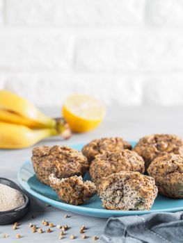 Close-up view of healthy gluten-free homemmade banana muffins with buckwheat flour. Vegan muffins with poppy seeds on blue plate over gray wooden table. Copy space