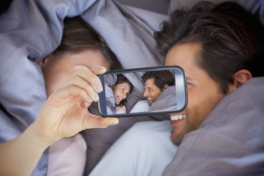 Composite of Couple taking selfie on smartphone