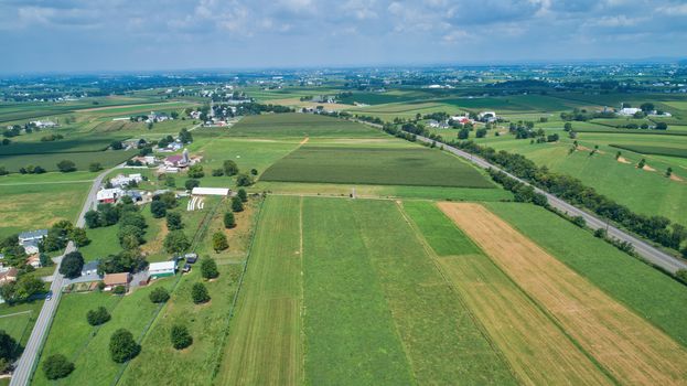 Aerial view of farm lands in summer with blue skies and white fluffy clouds