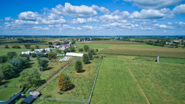Aerial view of green farmlands and rolling crops growing on a beautiful sky on a sunny countryside