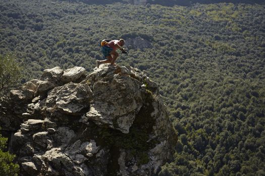 Climber boy on the rocks in Sardinia during sunset time