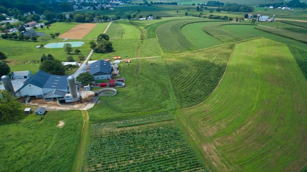Aerial view of green farmlands and rolling crops growing on a beautiful sky on a sunny countryside