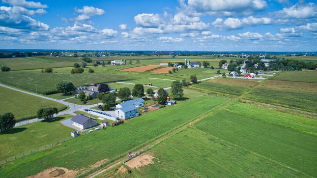 Aerial view of green farmlands and rolling crops growing on a beautiful sky on a sunny countryside