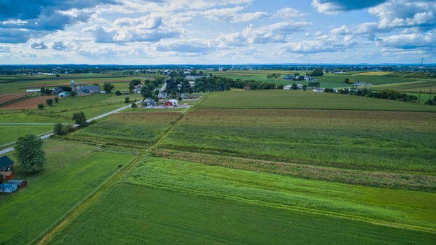 Aerial view of Amish countryside with barns and silos on a sunny summer day