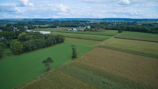 Aerial view of Amish countryside with barns and silos on a sunny summer day