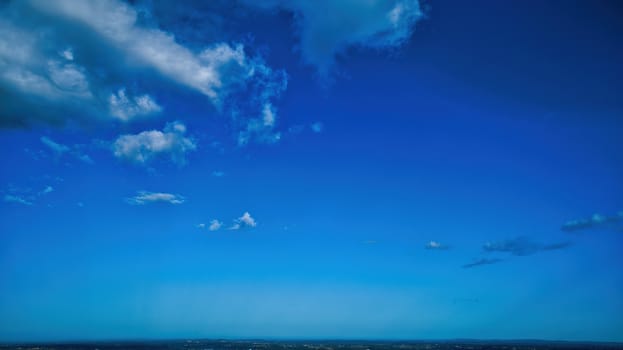 Blue sky and multiple clouds background showing a horizon