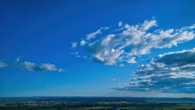 Blue sky and multiple clouds background showing a horizon