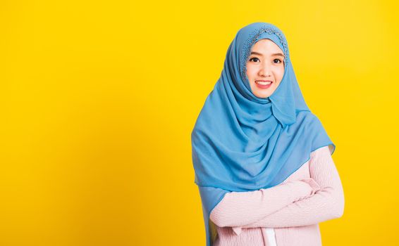 Asian Muslim Arab, Portrait of happy beautiful young woman religious wear veil hijab smiling she standing crossed arm studio shot isolated, yellow background with copy space, Close up skin face