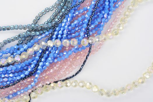 Mix of color faceted glass sparkle beads. Materials for creative work on white background.