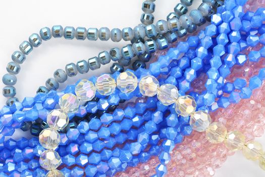 Mix of color faceted glass sparkle beads. Materials for creative work on white background.