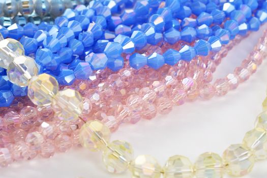 Mix of color faceted glass sparkle beads. Materials for creative work on white background.