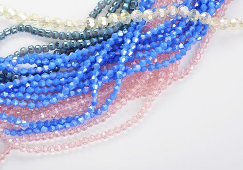 Mix of color faceted glass sparkle beads. Materials for creative work on white background.