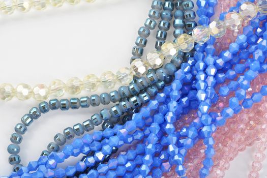 Mix of color faceted glass sparkle beads. Materials for creative work on white background.