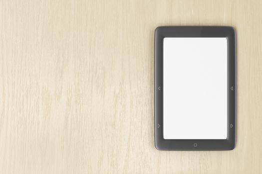 E-book reader with blank display on wood desk, top view