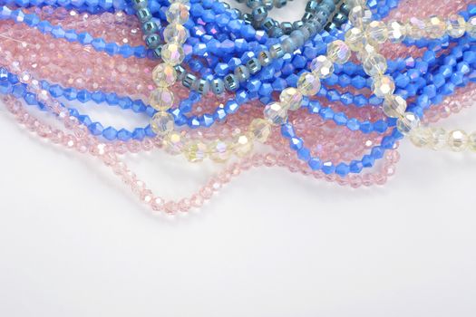 Mix of color faceted glass sparkle beads. Materials for creative work on white background.