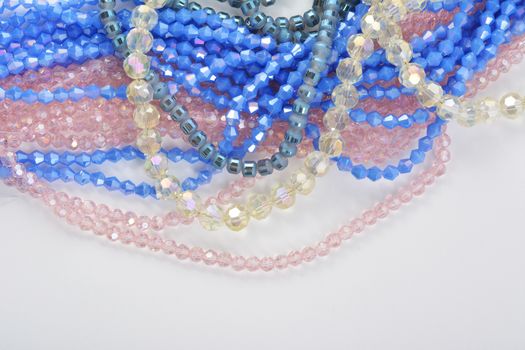 Mix of color faceted glass sparkle beads. Materials for creative work on white background.