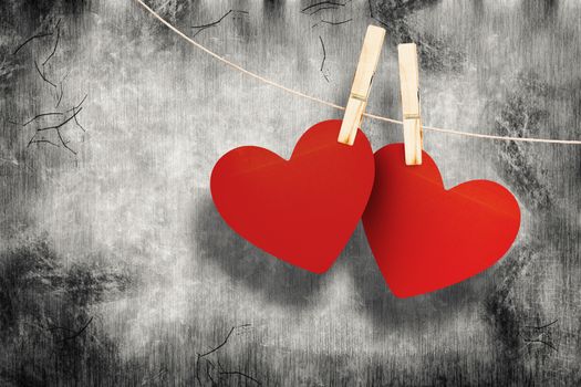 Hearts hanging on line against grey background