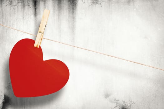 Heart hanging on line against grey background