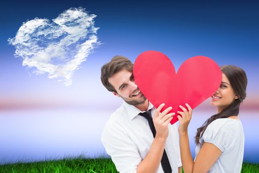 Couple smiling at camera holding a heart against cloud heart