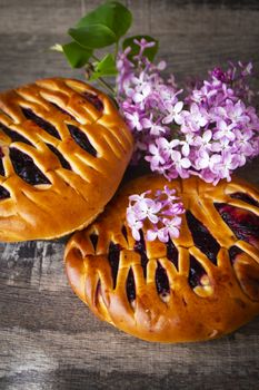 Brioche dough with blackcurrant, with violet lilac flowers, vertical image