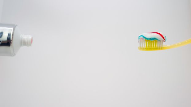 yellow toothbrush with toothpaste on it