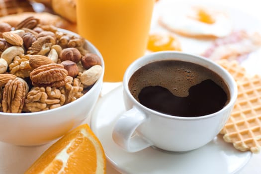 Healthy breakfast set with muesli, fruits, nuts, coffee, orange juice