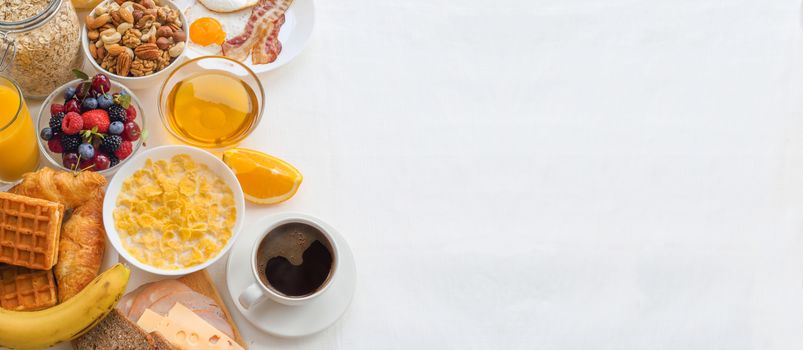 Healthy breakfast with muesli, fruits, berries, nuts, coffee, eggs, honey, oat grains and other on white background. Flat lay, top view, copy space for text, frame