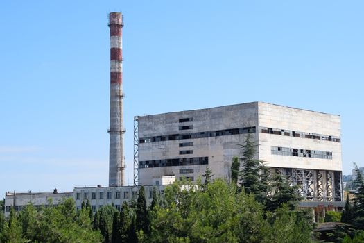 An old Soviet factory with a pipe. Abandoned Soviet industry.