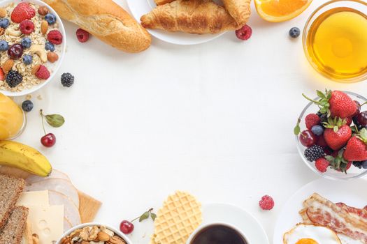 Healthy breakfast with muesli, fruits, berries, nuts, coffee, eggs, honey, oat grains and other on white background. Flat lay, top view, copy space for text, frame