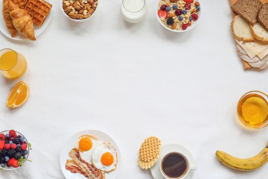 Healthy breakfast with muesli, fruits, berries, nuts, coffee, eggs, honey, oat grains and other on white background. Flat lay, top view, copy space for text, frame